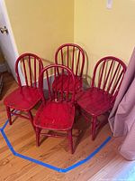 All four red wooden children’s chairs grouped