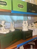 Shelf with three Snowbabies figurines and original green boxes