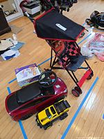 All items grouped: stroller, ride-on car, Tonka truck, board game boxes visible