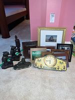 Group shot of entire lot including elephant statuettes, bronze lion, wood figure, vintage clock, multiple framed art pieces