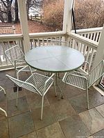 Full view of round glass table with four chairs