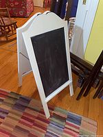 Front angled view of white framed chalkboard sign