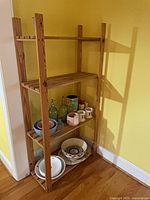 Front angled view of entire shelving unit showing four shelves and natural wood finish