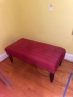 Full view of striped upholstered bench showing upholstery and legs