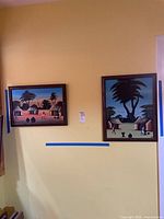 Both framed paintings on wall showing relative sizes and colours