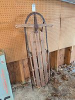 Full view of vintage wood sled on wall