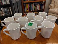 Front angled view of all ten mugs showing identical design and handles