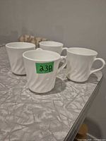 Four white Corning mugs front view on table