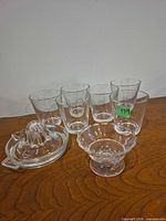 Lot overview showing six juice glasses, glass juicer, small footed dish