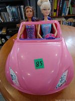 Front view of pink Barbie car with two dolls seated