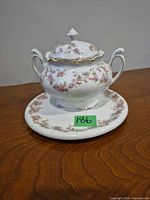 Covered sugar bowl on underplate showing pattern and form