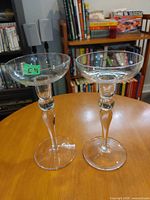 frontal view of both clear glass candle holders on table