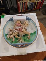 Plate in foam packaging showing 3-D carousel scene