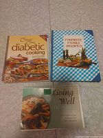 Front covers of the three spiral cookbooks