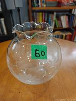 Side view of round crystal vase showing etched cornflower design and scalloped rim