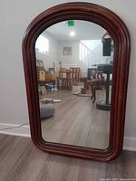 Front view of arched mirror in wooden frame