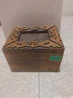 Front view of carved wooden box with lid closed