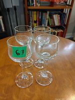 Set of four clear stemmed liqueur glasses grouped on table