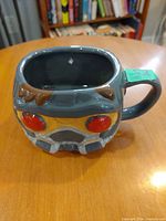 Three-quarter view showing sculpted helmet design and rim chip