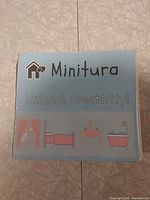 Front of Minitura diorama kit box with branding and miniature illustrations