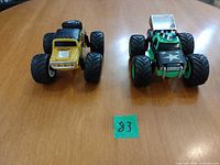 Both monster trucks side by side on table