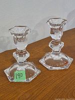 Pair of crystal candlesticks standing upright on tabletop