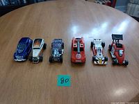 All six toy cars lined up on table