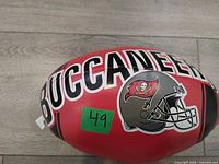 Side view showing BUCCANEER text and helmet logo on red football