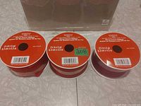 Three spools of red wired velvet ribbon front view