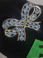 Front view showing bow shape and blue rhinestones