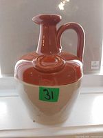 Front view of brown and beige pottery whiskey jug