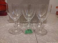 Front view of six crystal wine glasses standing in a row