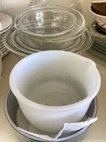 stack of clear glass bowls with white bowl visible, shows variety of bowls