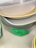 Stack showing clear glass round dish, rectangular dish, beige plate, plastic bowl