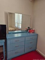 Front view of blue six-drawer dresser with attached mirror