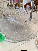 Handled square compote atop fluted round plate