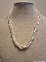 Full view of triple-strand baroque pearl necklace on bust