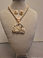 Entire jewelry set displayed on bust showing necklace and earrings