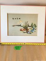 Framed embroidery with measuring tape indicating size