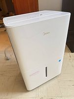 Front and side view of Midea dehumidifier with power cord visible
