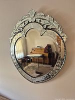 Full view of ornate heart-top Venetian mirror on wall