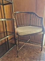 Angled full view of the rattan/bamboo armchair with cushion