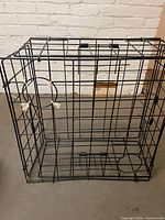 Overall view of black wire crab trap showing entry funnels and hinged top