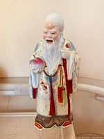 Full view of Shou Xing porcelain figurine showing paint, details, and overall condition