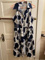 Full view of sleeveless button-front printed dress on hanger