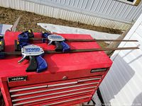 Two 45-inch Irwin Quick-Grip bar clamps on red tool chest