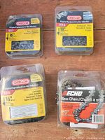 Four packaged chainsaw chains laid out