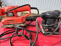 Both corded electric sanders side by side