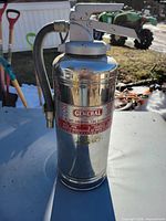 Full view of chrome General fire extinguisher with hose and lever