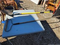 Rake and shovel laid on table full length view
